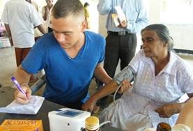 Verpleegkunde vrijwilligerswerk in het buitenland:Een verpleegkunde vrijwilliger help een patient in Sri Lanka bij het meten van de bloeddruk. Een verpleegkunde vrijwilliger help een patient in Sri Lanka bij het meten van de bloeddruk.