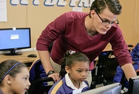 Vrijwilligerswerk in Zuid-Afrika:Een vrijwilliger van het computervaardigheden project helpt scholieren in Kaapstad bij de opdrachten. Een vrijwilliger van het computervaardigheden project helpt scholieren in Kaapstad bij de opdrachten.
