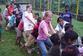 Sociaal vrijwilligerswerk met kinderen in het buitenland:Vrijwilligers op het sociale project in Sri Lanka nemen deel aan de spelletjes op het schoolplein. Vrijwilligers op het sociale project in Sri Lanka nemen deel aan de spelletjes op het schoolplein.