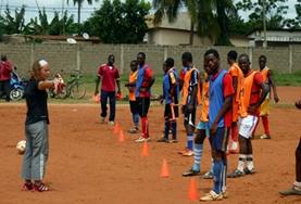 Vrijwilligerswerk in Togo:Een vrijwilliger geeft instructies aan het lokale voetbal team tijdens dit sport en voetbal project in Togo. Een vrijwilliger geeft instructies aan het lokale voetbal team tijdens dit sport en voetbal project in Togo.